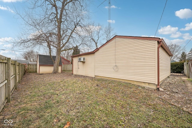 view of side of property featuring an AC wall unit, a lawn, and a storage unit