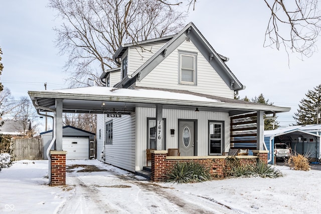 view of front facade featuring a garage, an outbuilding, and a porch