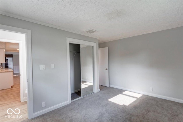 1002 Payton Ave, Indianapolis, IN 46219 - unfurnished bedroom featuring light carpet, ornamental molding, a closet, and a textured ceiling
