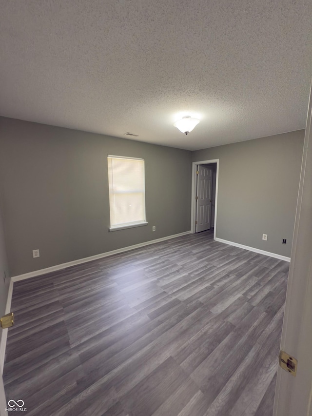 unfurnished room with wood-type flooring and a textured ceiling