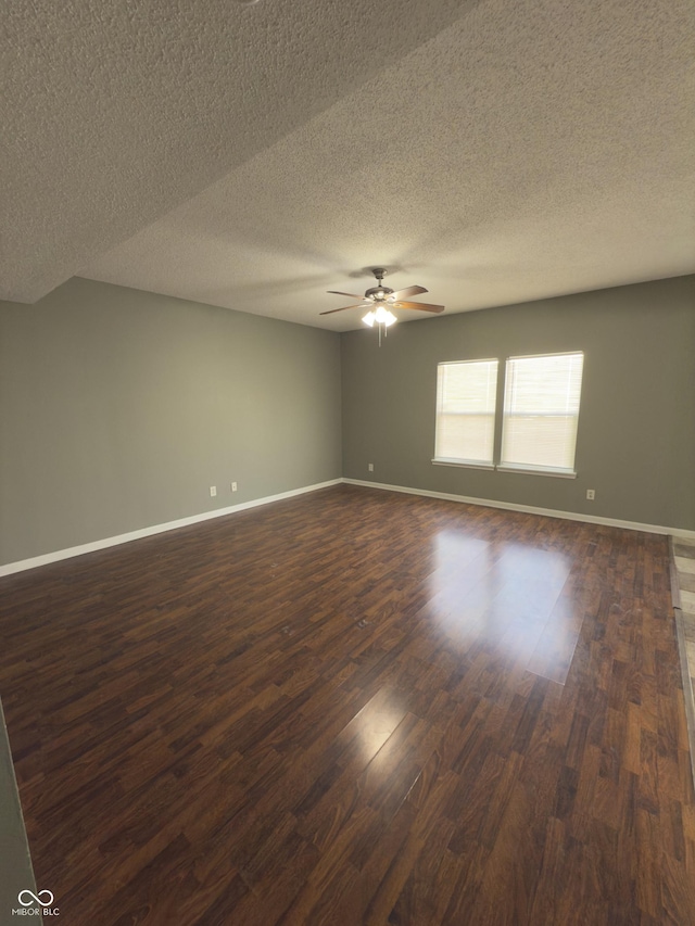 empty room with ceiling fan, dark hardwood / wood-style floors, and a textured ceiling