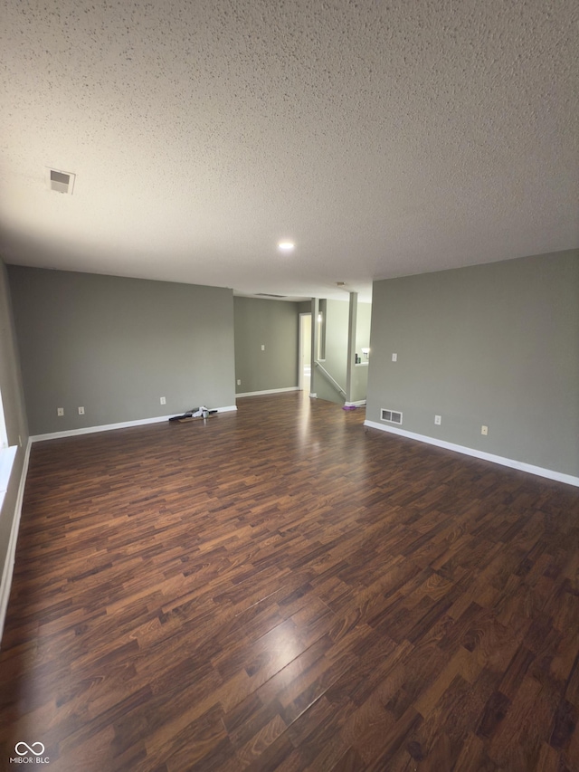 empty room featuring dark hardwood / wood-style floors and a textured ceiling