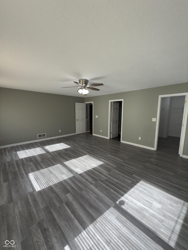 empty room featuring ceiling fan, dark hardwood / wood-style floors, and a textured ceiling