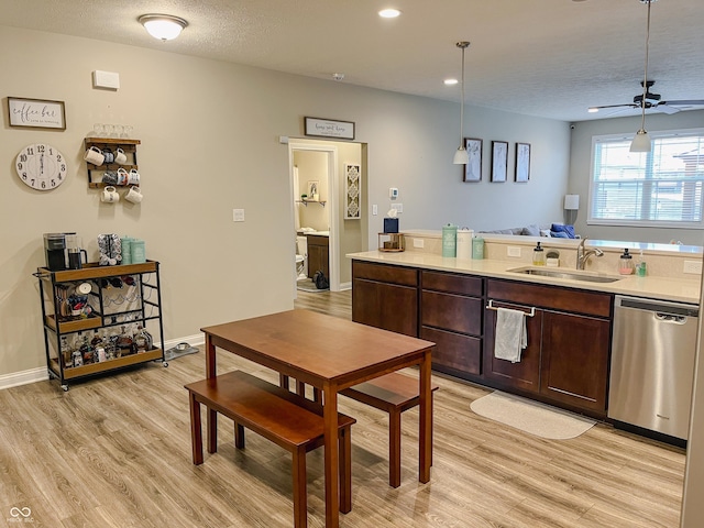 kitchen with sink, light hardwood / wood-style flooring, dark brown cabinets, decorative light fixtures, and stainless steel dishwasher