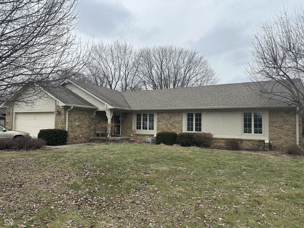 single story home with a garage and a front lawn