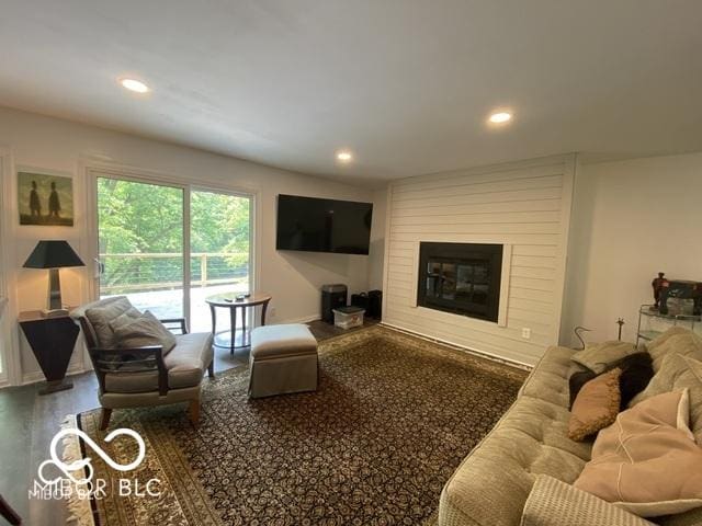 living area with a fireplace, wood finished floors, and recessed lighting