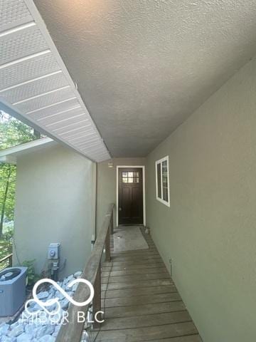 doorway to property featuring central AC unit and stucco siding