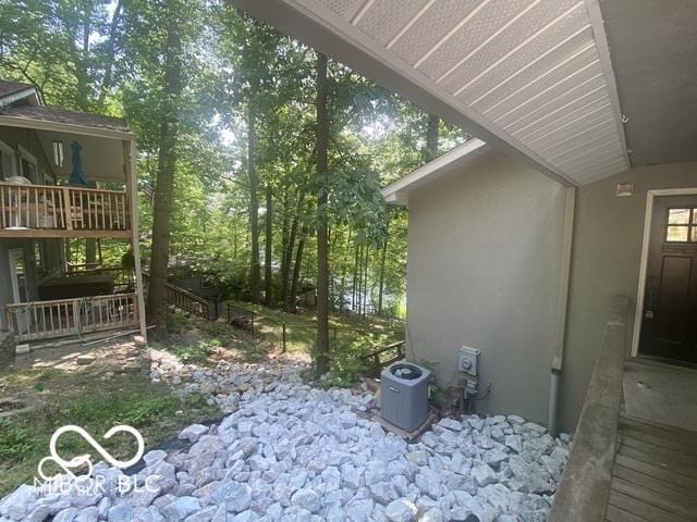 view of side of home with central AC and stucco siding