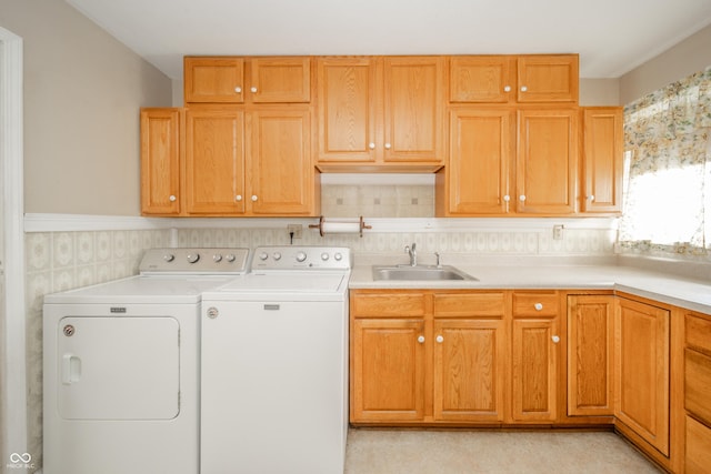 laundry room featuring separate washer and dryer, sink, and cabinets