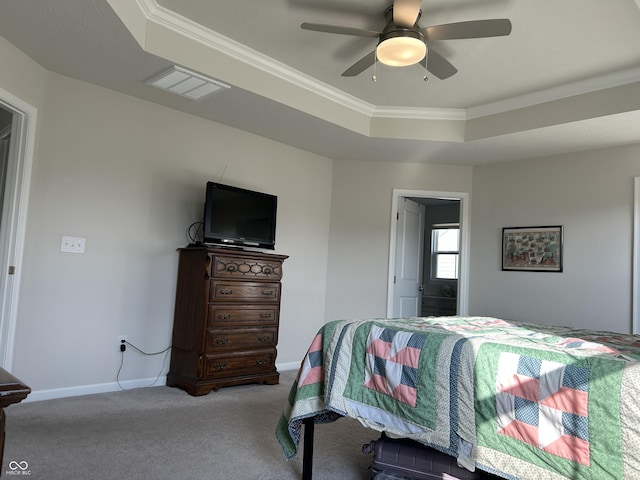 carpeted bedroom featuring a raised ceiling, ornamental molding, and ceiling fan