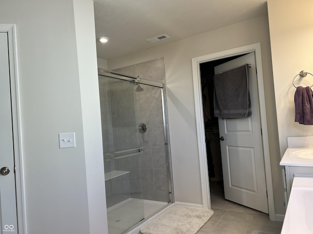 bathroom with vanity, tile patterned flooring, and a shower with door