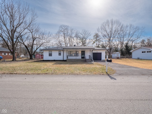 ranch-style house featuring a garage, covered porch, and a front lawn