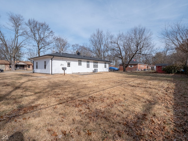 back of property with a yard and central air condition unit