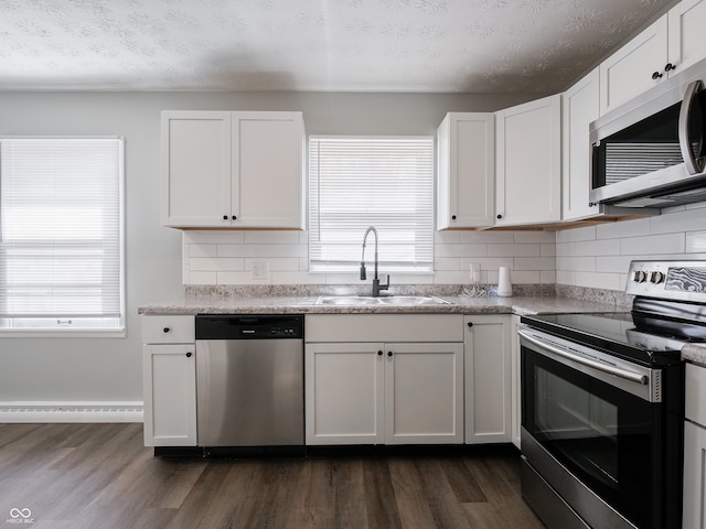 kitchen with stainless steel appliances, sink, and white cabinets