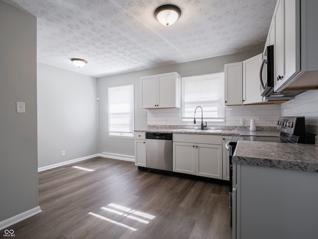 kitchen with sink, tasteful backsplash, dark hardwood / wood-style floors, dishwasher, and white cabinets