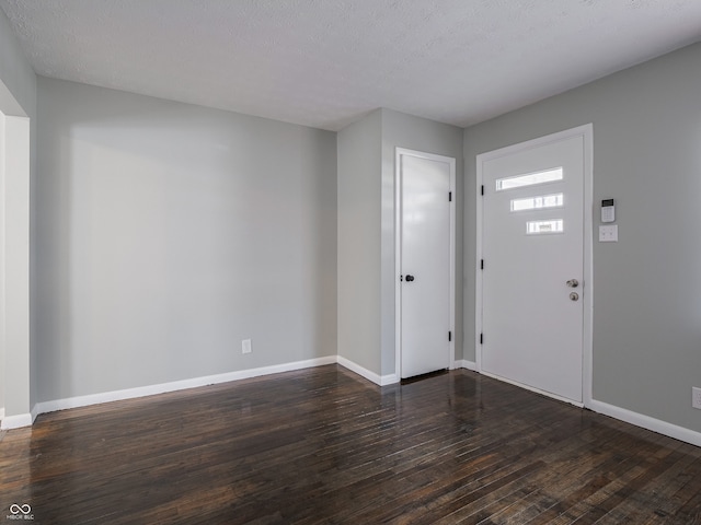 foyer entrance featuring dark hardwood / wood-style flooring and a textured ceiling