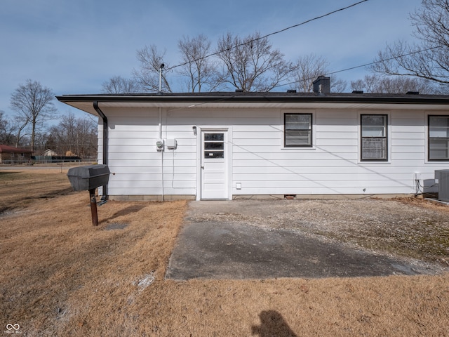 rear view of property featuring a lawn