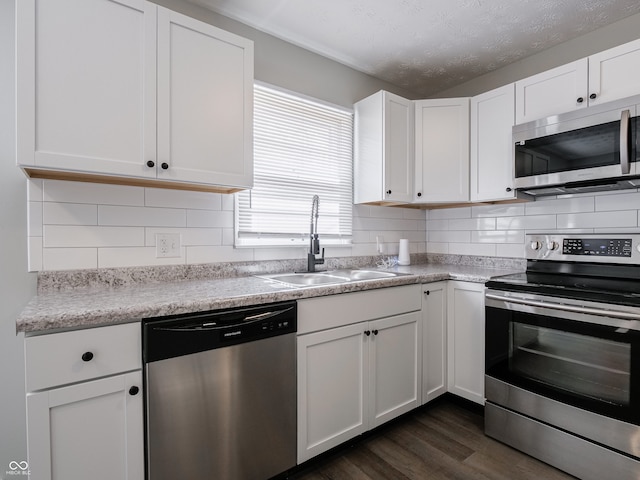 kitchen with sink, stainless steel appliances, dark hardwood / wood-style floors, and white cabinets