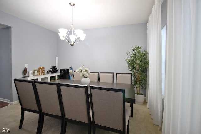 dining room with carpet flooring and a notable chandelier