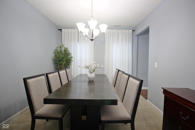 dining room with a chandelier and light carpet