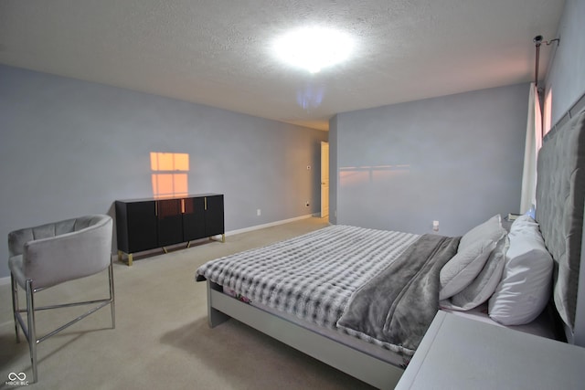 bedroom with light carpet and a textured ceiling