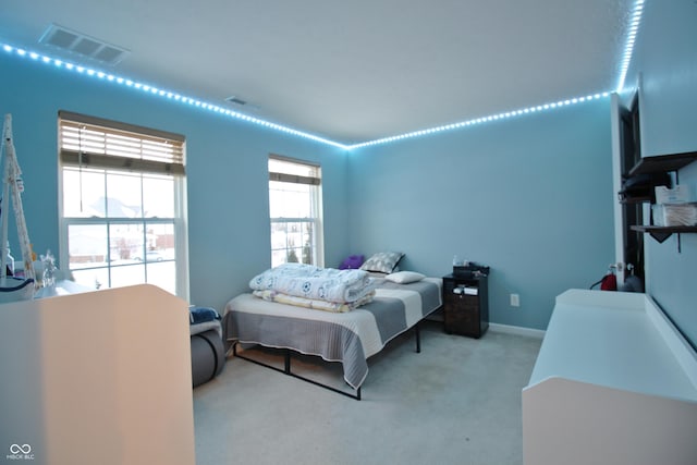 bedroom with multiple windows and light colored carpet