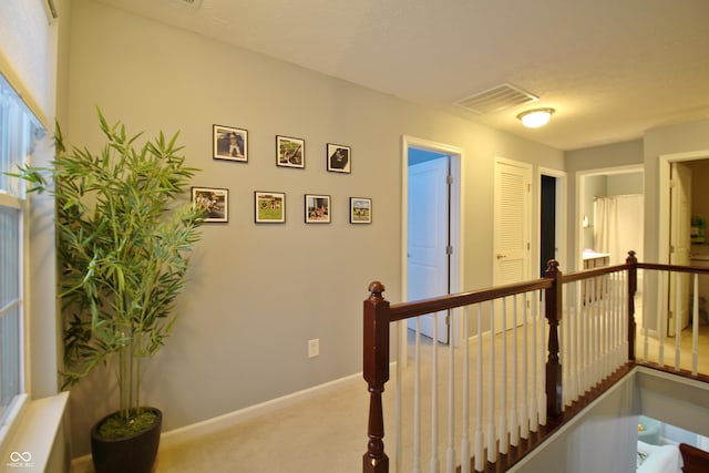 hall with light colored carpet