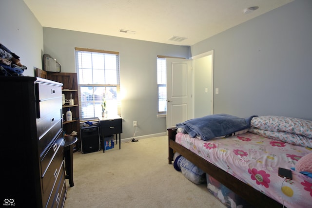 bedroom with multiple windows and light colored carpet