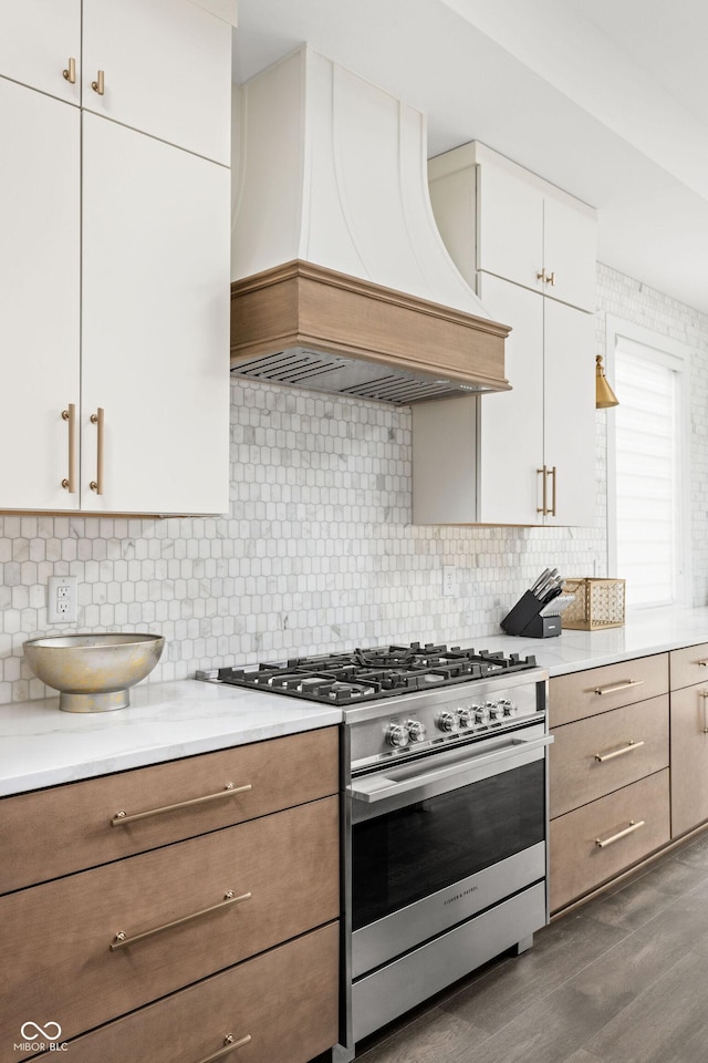 kitchen featuring custom exhaust hood, white cabinetry, tasteful backsplash, stainless steel range with gas stovetop, and dark hardwood / wood-style floors