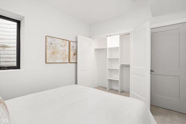 bedroom with light colored carpet and a closet