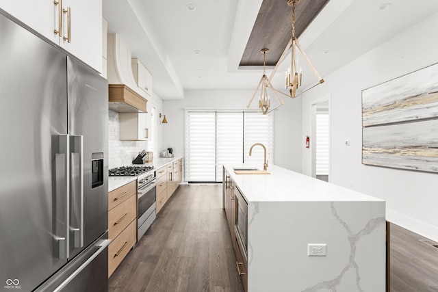 kitchen featuring sink, hanging light fixtures, premium appliances, a center island with sink, and custom exhaust hood