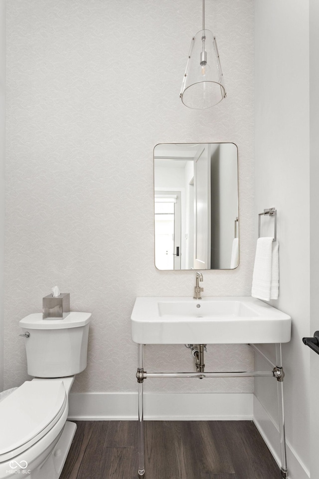 bathroom with hardwood / wood-style floors, sink, and toilet