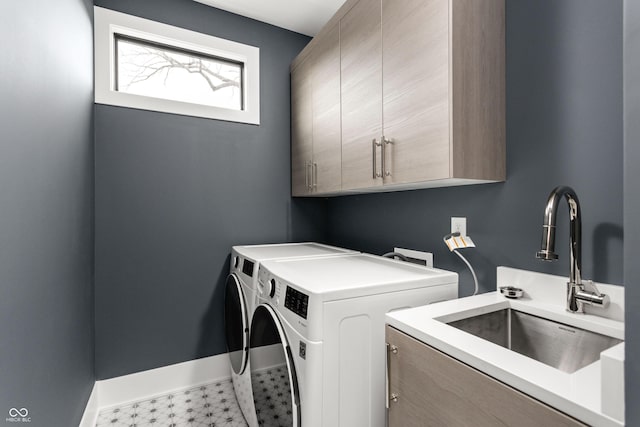 washroom with cabinets, separate washer and dryer, and sink