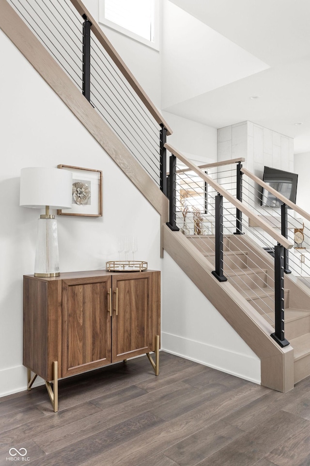 stairs with a towering ceiling and wood-type flooring