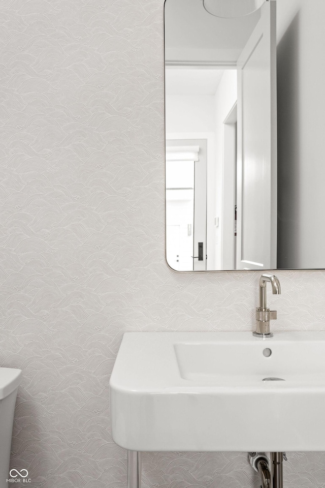 bathroom with toilet, sink, and backsplash