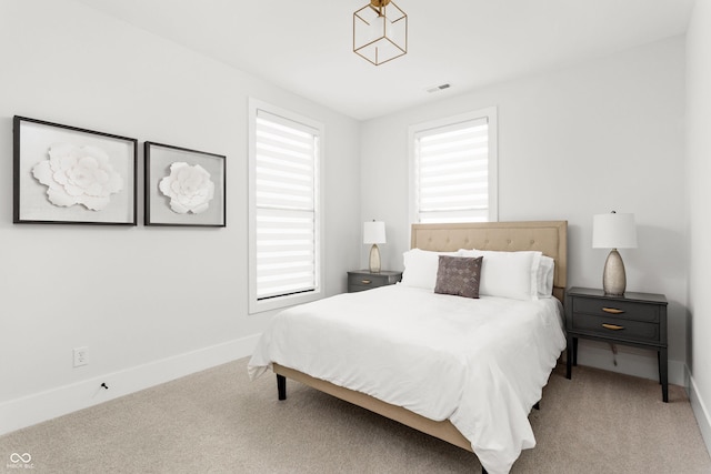 bedroom featuring multiple windows and light colored carpet