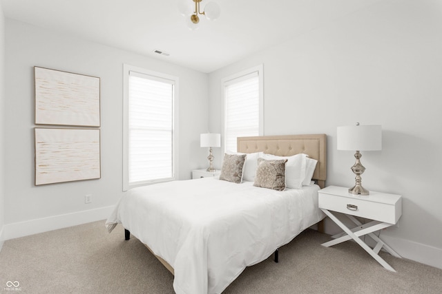 carpeted bedroom featuring multiple windows