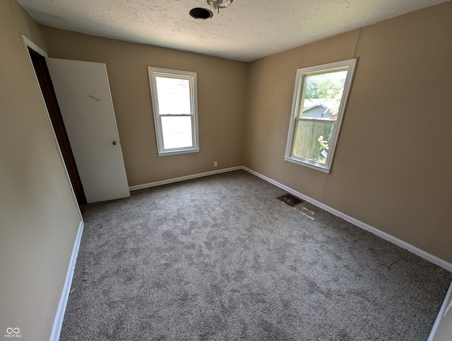 603 W 33rd St, Anderson, IN 46013 - carpeted empty room with plenty of natural light and a textured ceiling