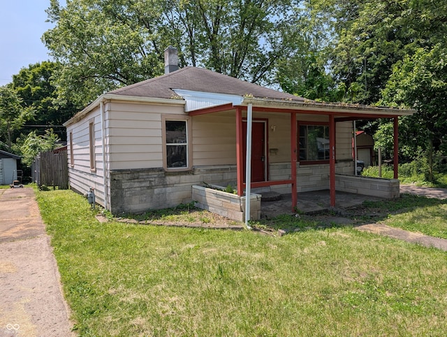 603 W 33rd St, Anderson, IN 46013 - view of front of property with roof with shingles, a front lawn, and a chimney