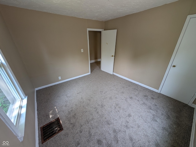 603 W 33rd St, Anderson, IN 46013 - unfurnished bedroom featuring carpet floors and a textured ceiling