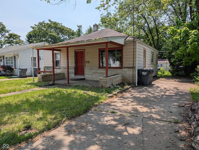 603 W 33rd St, Anderson, IN 46013 - view of front of house with a chimney, concrete driveway, and a front yard