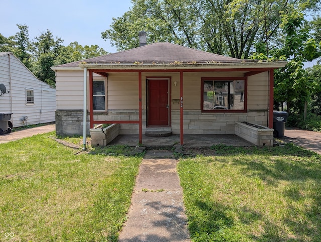 603 W 33rd St, Anderson, IN 46013 - view of front of property with a front yard, roof with shingles, a chimney, and covered porch