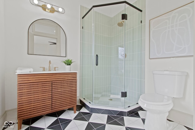 bathroom with vanity, a shower with shower door, tile patterned floors, and toilet