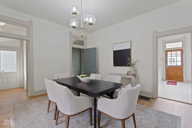 dining room featuring an inviting chandelier and light hardwood / wood-style flooring