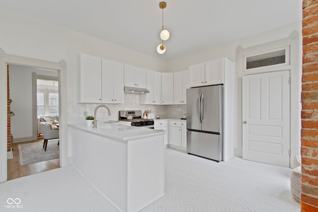 kitchen featuring white cabinetry, stainless steel appliances, sink, and hanging light fixtures