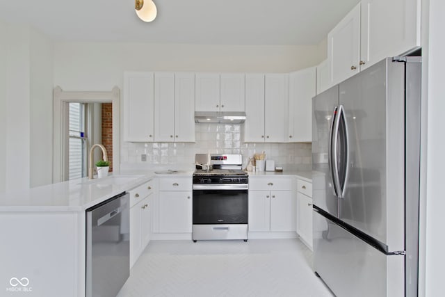 kitchen with sink, stainless steel appliances, kitchen peninsula, and white cabinets