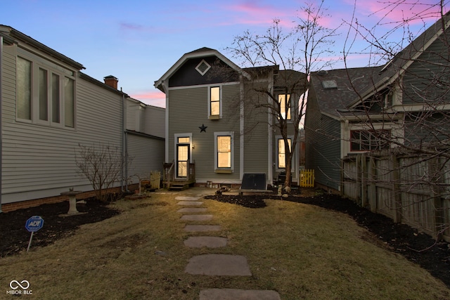 back house at dusk with a lawn