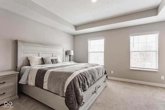 bedroom with light carpet, baseboards, and a textured ceiling