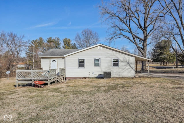 back of house featuring cooling unit, a carport, a deck, and a lawn