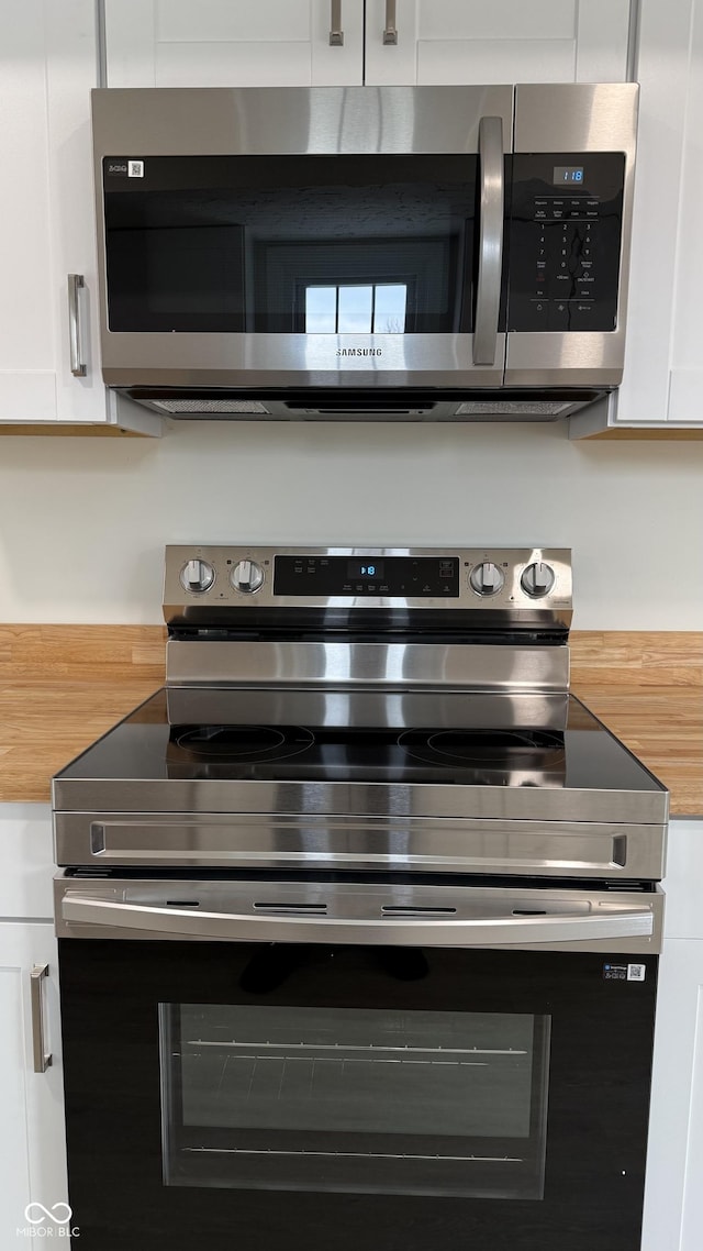 interior details with white cabinets and appliances with stainless steel finishes